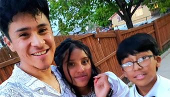 Man smiling while posing with a woman and a boy.