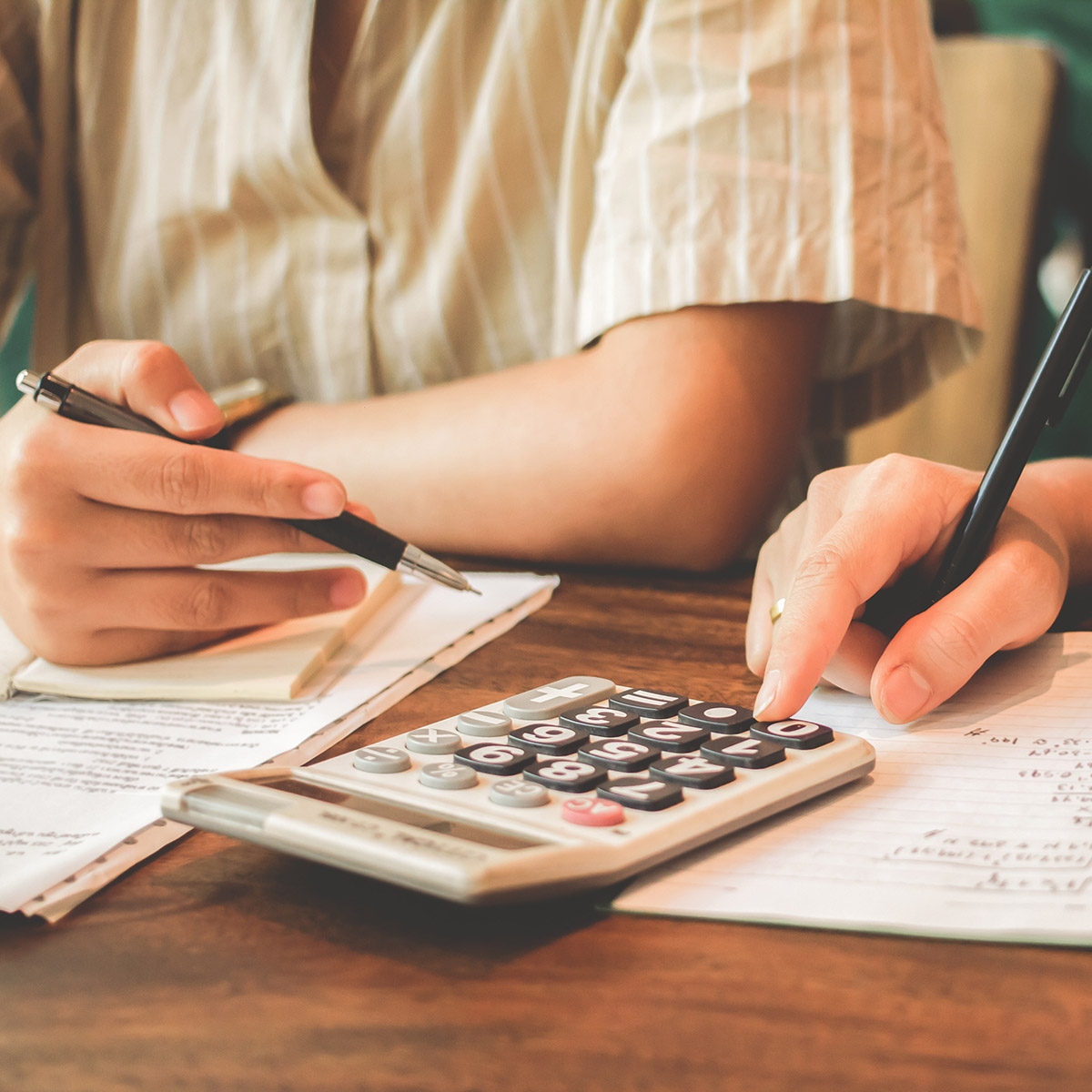 close-up of hands using a calculator
