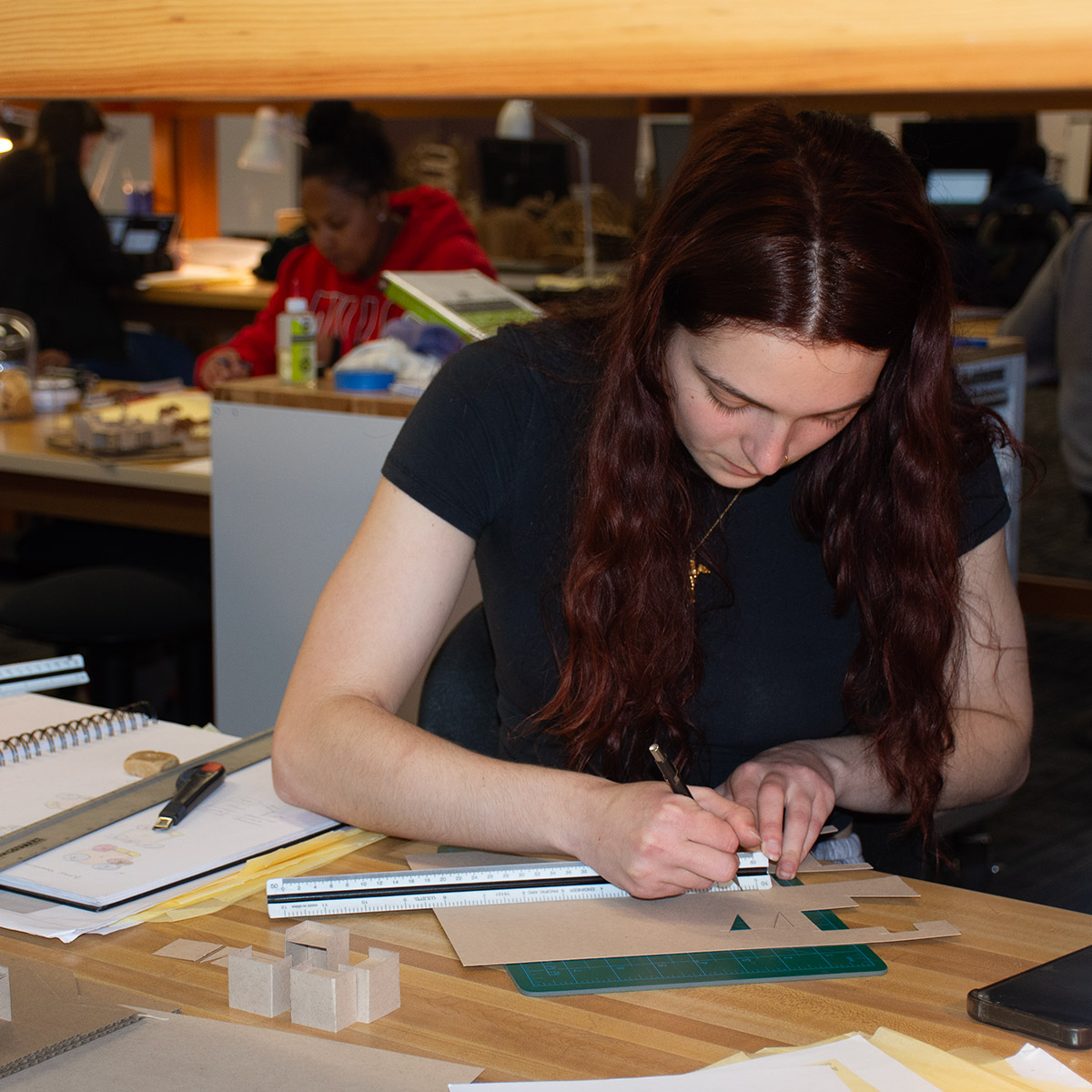 white, female CCD Architectural Technologies building a model