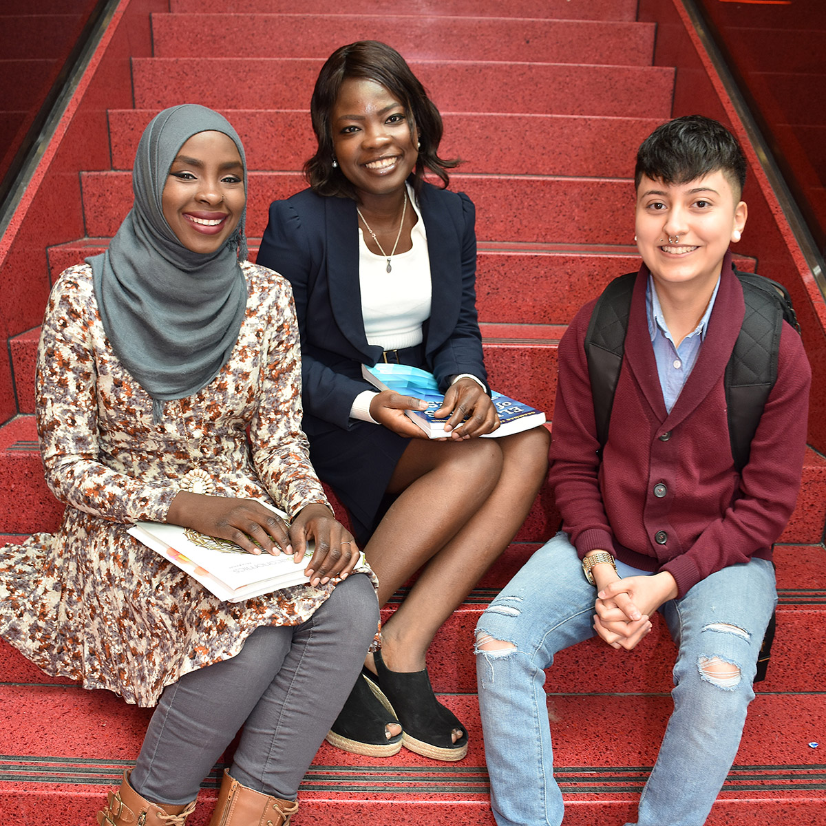 three CCD students sitting on a staircase