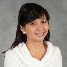 Woman with shoulder-length black hair wearing white sweater