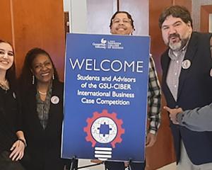 Students holding sign and pointing at it 