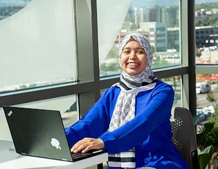 Students sitting at a tables on their laptops and iPads