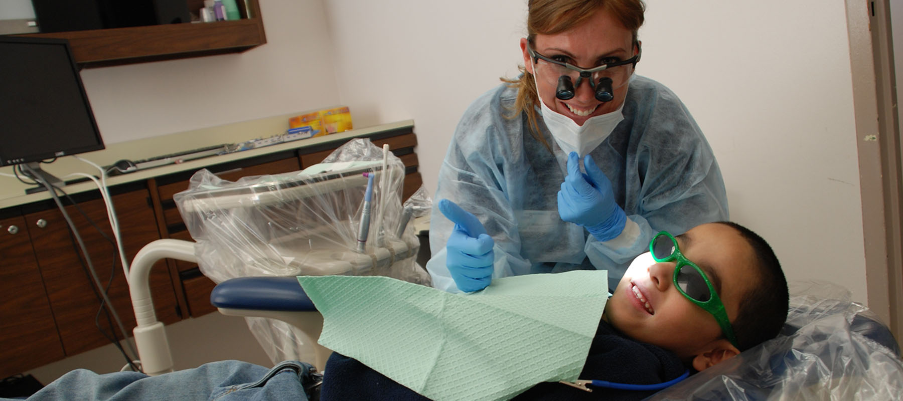 a child with googles on gets his teeth cleaned at the dentist