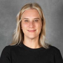 Woman with shoulder length blond hair wearing a black top
